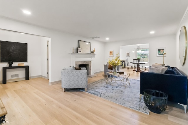 8246 Windcombe Blvd, Indianapolis, IN 46240 - living room featuring wood finished floors, a high end fireplace, recessed lighting, and a chandelier