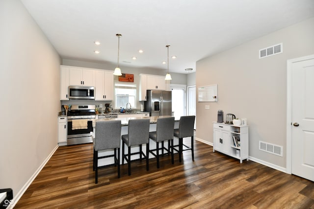 3443 Thomas Jefferson St, Westfield, IN 46074 - kitchen with stainless steel appliances, a breakfast bar, dark wood-type flooring, white cabinets, and recessed lighting