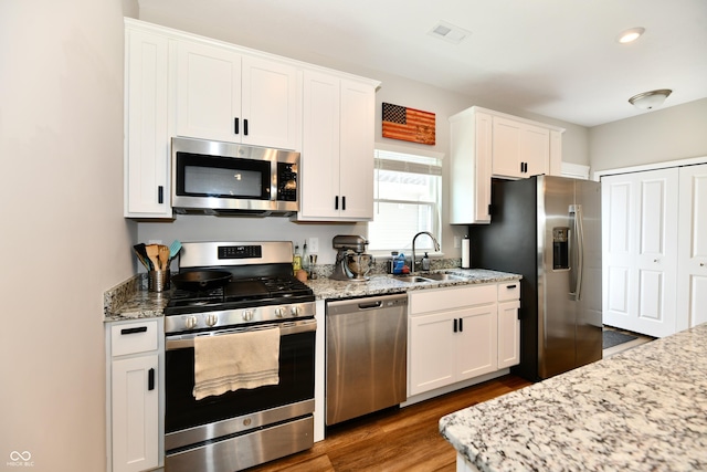 3443 Thomas Jefferson St, Westfield, IN 46074 - kitchen featuring stainless steel appliances, white cabinetry, wood finished floors, light stone countertops, and recessed lighting