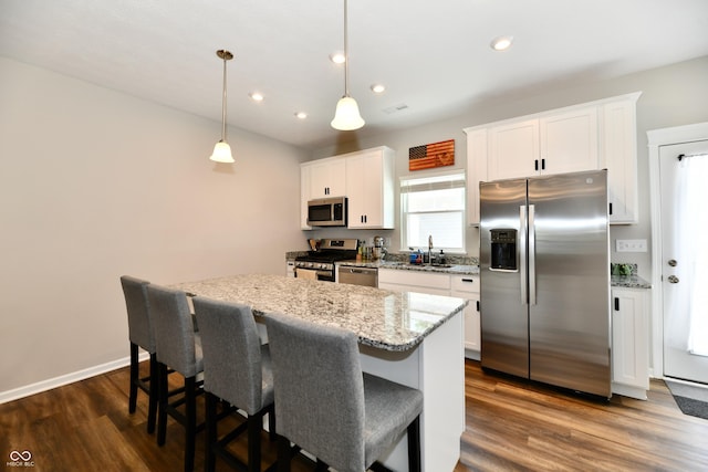 3443 Thomas Jefferson St, Westfield, IN 46074 - kitchen with stainless steel appliances, a center island, white cabinets, dark wood-style flooring, and a breakfast bar