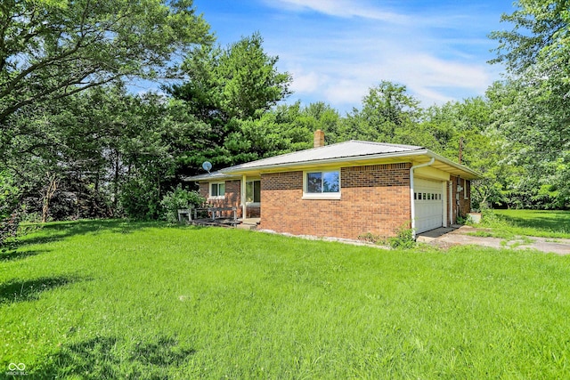 10159 Hodge Rd, Clayton, IN 46118 - view of front facade featuring a chimney, brick siding, a front yard, a garage, and driveway