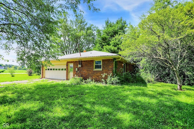 10159 Hodge Rd, Clayton, IN 46118 - view of front of house featuring a garage, brick siding, a chimney, driveway, and a metal roof