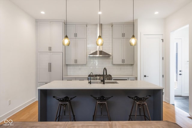 1905 N Alabama St, Indianapolis, IN 46202 - kitchen with light wood-style floors, a breakfast bar area, tasteful backsplash, an island with sink, and light countertops