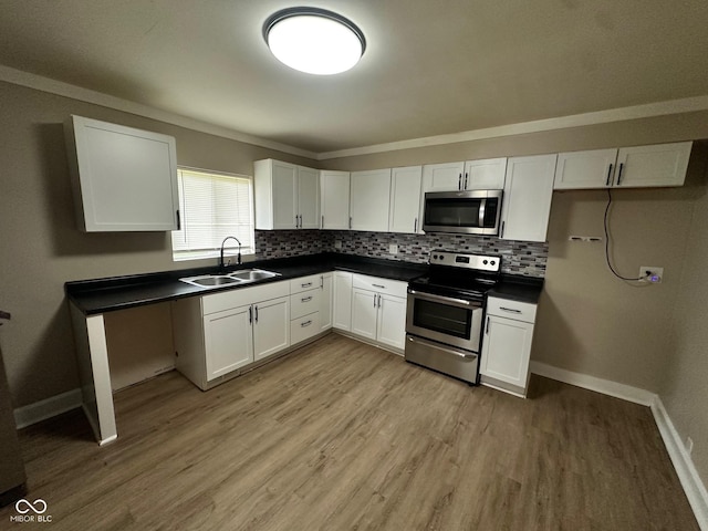 1810 N Parker Ave, Indianapolis, IN 46218 - kitchen with stainless steel appliances, dark countertops, white cabinets, light wood-style floors, and backsplash