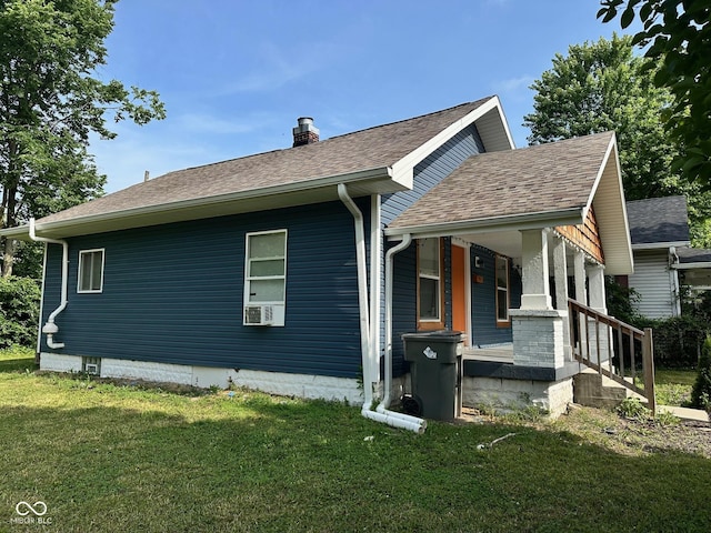 1810 N Parker Ave, Indianapolis, IN 46218 - view of side of home with a porch, a lawn, a chimney, and roof with shingles