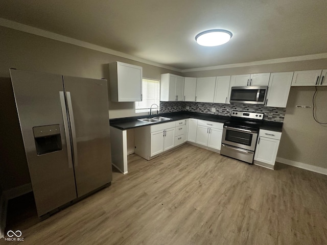 1810 N Parker Ave, Indianapolis, IN 46218 - kitchen with stainless steel appliances, dark countertops, light wood-style flooring, ornamental molding, and white cabinetry