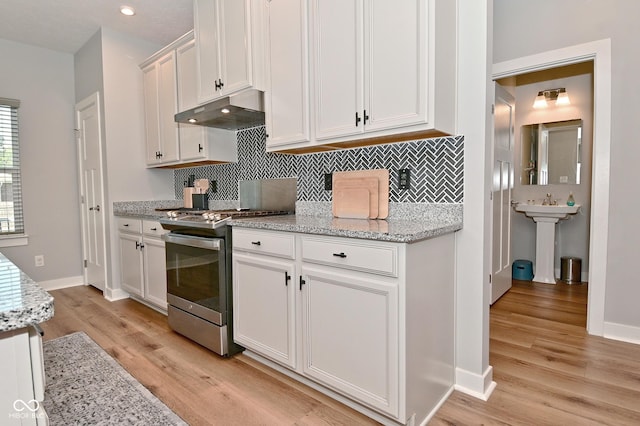 2734 Chalbury Dr, Plainfield, IN 46168 - kitchen featuring stainless steel range with gas stovetop, under cabinet range hood, light wood finished floors, decorative backsplash, and recessed lighting