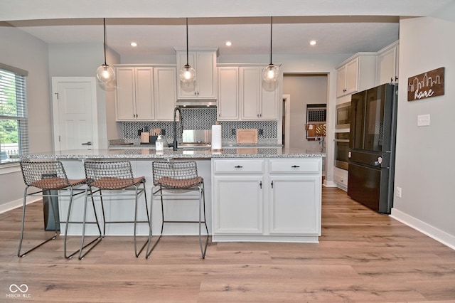 2734 Chalbury Dr, Plainfield, IN 46168 - kitchen featuring stainless steel appliances, white cabinets, decorative backsplash, light wood-type flooring, and recessed lighting