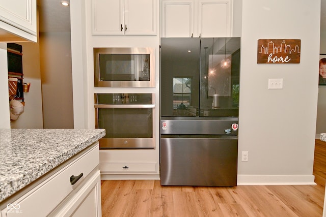 2734 Chalbury Dr, Plainfield, IN 46168 - kitchen with stainless steel appliances, light wood-style floors, white cabinetry, and light stone counters