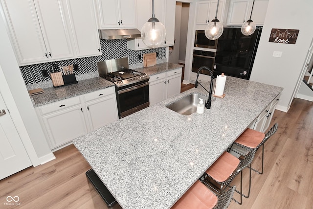 2734 Chalbury Dr, Plainfield, IN 46168 - kitchen featuring gas range, oven, under cabinet range hood, refrigerator, and light wood finished floors