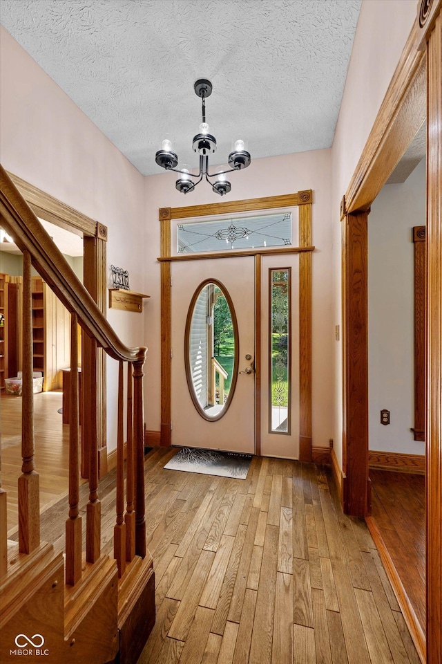 7516 S County Road 300 W, Clayton, IN 46118 - foyer with light wood-type flooring, a chandelier, stairway, and a textured ceiling