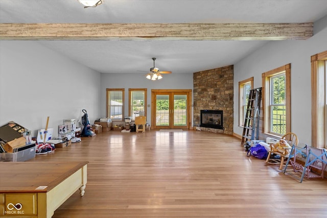 7516 S County Road 300 W, Clayton, IN 46118 - living room with beamed ceiling, healthy amount of natural light, wood finished floors, a ceiling fan, and a stone fireplace