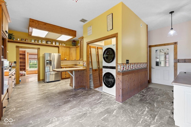 7516 S County Road 300 W, Clayton, IN 46118 - kitchen with appliances with stainless steel finishes, stacked washer / drying machine, light marble finish flooring, light countertops, and decorative light fixtures