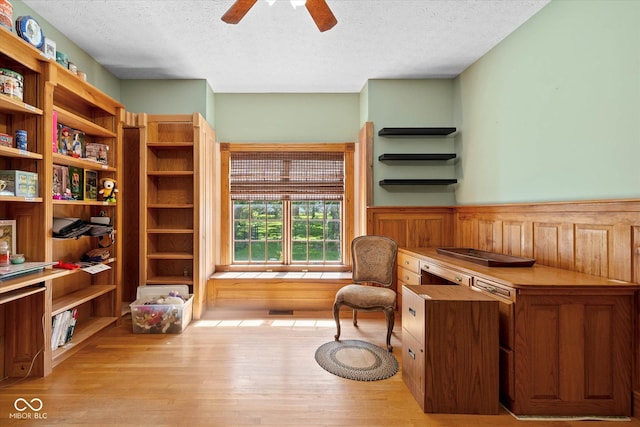 7516 S County Road 300 W, Clayton, IN 46118 - living area featuring a textured ceiling, wood finished floors, ceiling fan, and a wainscoted wall
