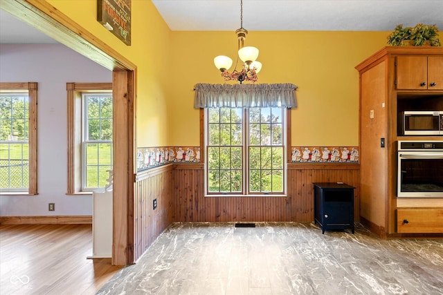 7516 S County Road 300 W, Clayton, IN 46118 - unfurnished dining area featuring wood finished floors, wainscoting, a chandelier, healthy amount of natural light, and wood walls