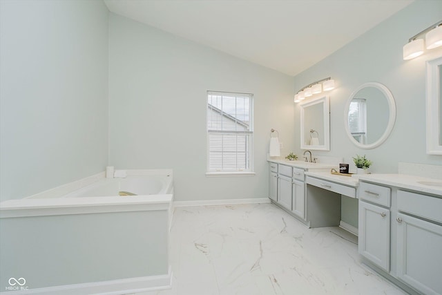 12490 Windbush Way, Carmel, IN 46033 - bathroom featuring vanity, vaulted ceiling, marble look tiles, and a garden tub
