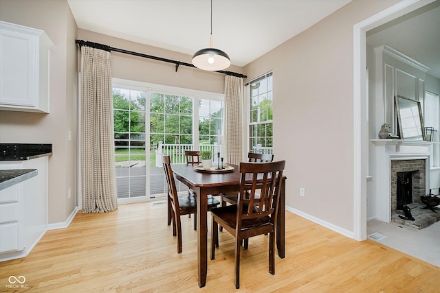 12490 Windbush Way, Carmel, IN 46033 - dining area with light wood-type flooring and a brick fireplace