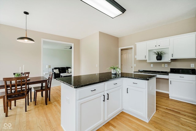 12490 Windbush Way, Carmel, IN 46033 - kitchen with light wood-style floors, a center island, white cabinets, decorative light fixtures, and dark stone counters