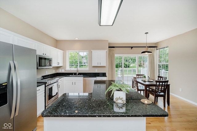 12490 Windbush Way, Carmel, IN 46033 - kitchen with appliances with stainless steel finishes, light wood-style floors, white cabinetry, and pendant lighting
