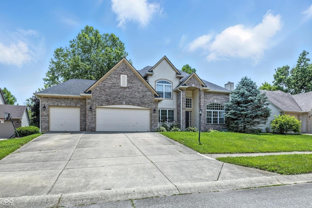 2463 Kettering Way, Indianapolis, IN 46214 - traditional-style home with an attached garage, brick siding, concrete driveway, a front yard, and a chimney
