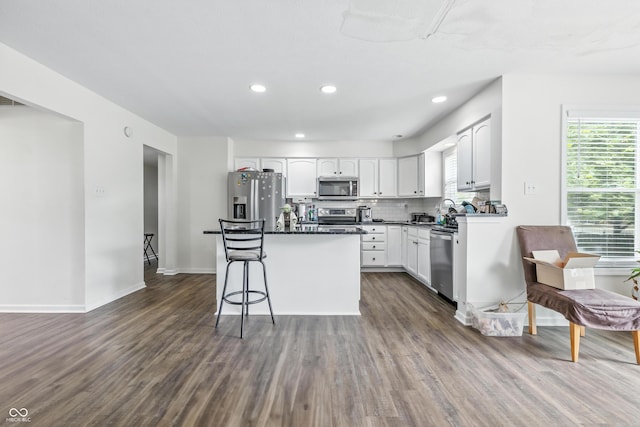 2463 Kettering Way, Indianapolis, IN 46214 - kitchen with stainless steel appliances, dark wood-type flooring, white cabinets, a kitchen island, and dark countertops