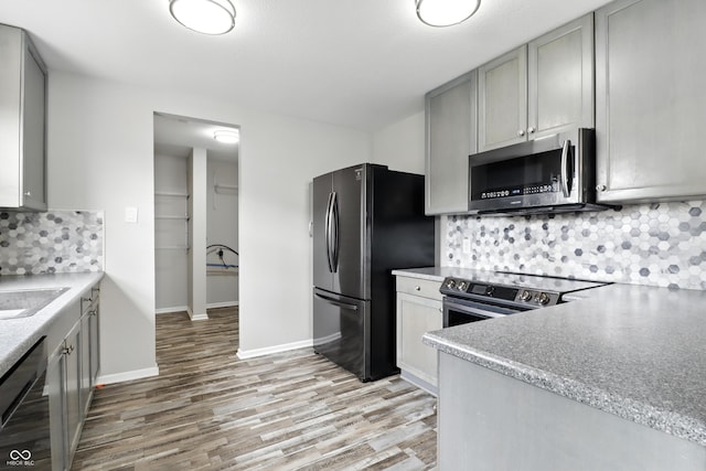 1236 N Aberdeen Dr, Franklin, IN 46131 - kitchen featuring stainless steel appliances, gray cabinetry, light wood-type flooring, and decorative backsplash