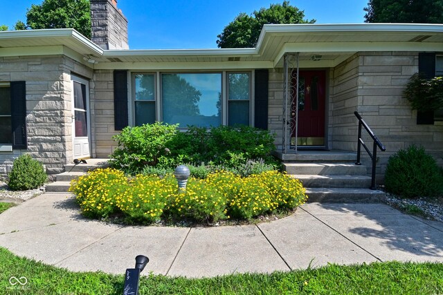 136 W Loretta Dr, Indianapolis, IN 46217 - doorway to property featuring a chimney and stone siding