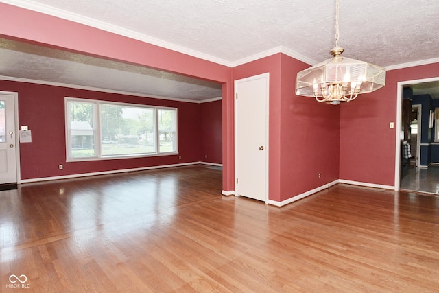 136 W Loretta Dr, Indianapolis, IN 46217 - spare room featuring wood finished floors, a chandelier, a textured ceiling, and crown molding