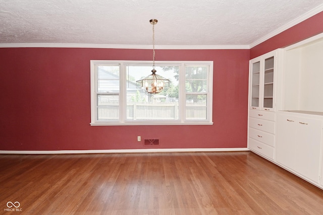 136 W Loretta Dr, Indianapolis, IN 46217 - unfurnished dining area with wood finished floors, a chandelier, a textured ceiling, and ornamental molding