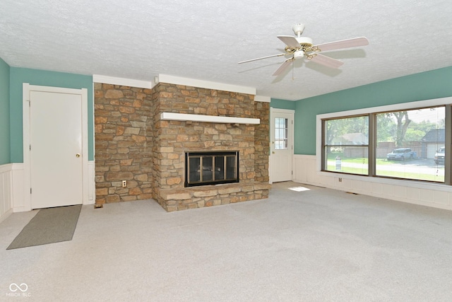 136 W Loretta Dr, Indianapolis, IN 46217 - unfurnished living room with a textured ceiling, a wainscoted wall, a ceiling fan, carpet floors, and healthy amount of natural light