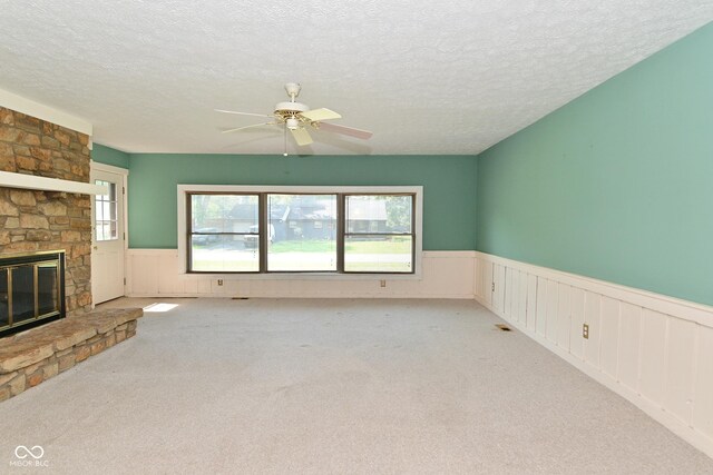 136 W Loretta Dr, Indianapolis, IN 46217 - unfurnished living room with a wainscoted wall, carpet, a ceiling fan, a textured ceiling, and a fireplace
