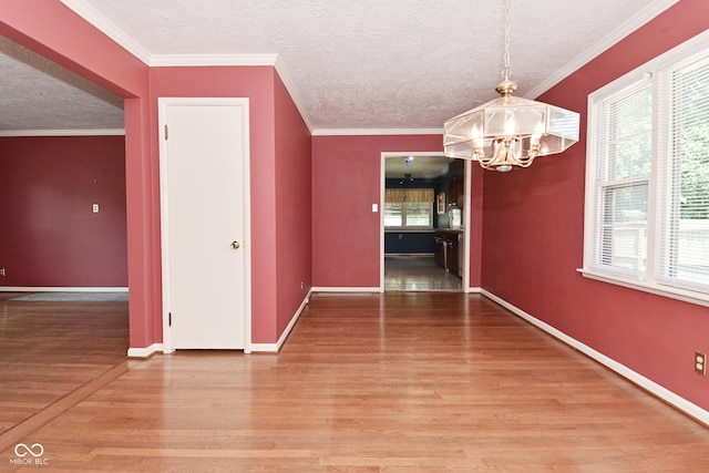 136 W Loretta Dr, Indianapolis, IN 46217 - unfurnished dining area featuring a chandelier, light wood-style floors, a textured ceiling, and ornamental molding