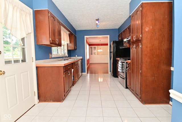 136 W Loretta Dr, Indianapolis, IN 46217 - kitchen featuring electric stove, healthy amount of natural light, light countertops, under cabinet range hood, and a textured ceiling