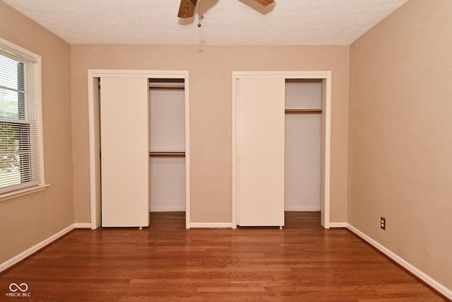 136 W Loretta Dr, Indianapolis, IN 46217 - unfurnished bedroom with multiple closets, wood finished floors, a ceiling fan, and a textured ceiling