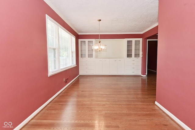 136 W Loretta Dr, Indianapolis, IN 46217 - unfurnished dining area featuring a chandelier, ornamental molding, light wood-style floors, and built in features