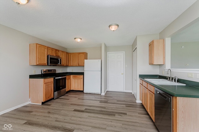 7572 Wymm Ln, Ingalls, IN 46048 - kitchen with stainless steel appliances, light wood finished floors, dark countertops, and a textured ceiling