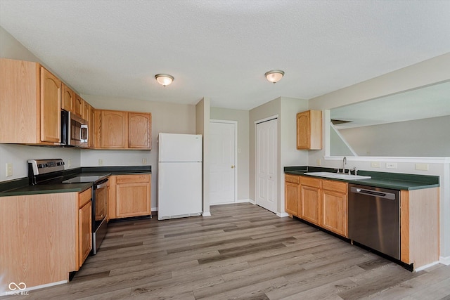 7572 Wymm Ln, Ingalls, IN 46048 - kitchen featuring appliances with stainless steel finishes, dark countertops, wood finished floors, a textured ceiling, and light brown cabinets