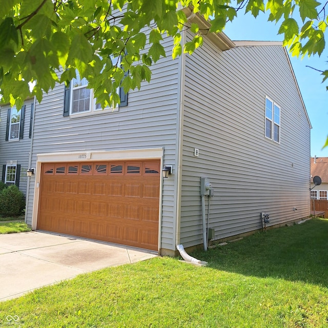 10775 Cyrus Dr, Indianapolis, IN 46231 - view of property exterior featuring a lawn, an attached garage, and concrete driveway