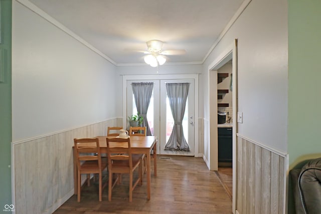 2587 E State Road 55, Wingate, IN 47994 - dining space with a wainscoted wall, wood finished floors, crown molding, wooden walls, and a ceiling fan
