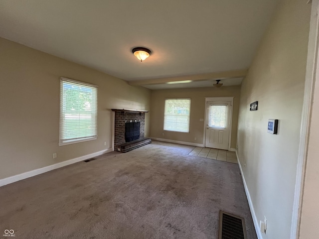 1900 S 25th St, Terre Haute, IN 47802 - unfurnished living room featuring plenty of natural light, a fireplace, and light colored carpet
