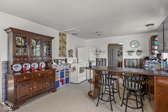 9030 E 700 S, Elizabethtown, IN 47232 - kitchen with white appliances, dark countertops, a breakfast bar area, glass insert cabinets, and a peninsula