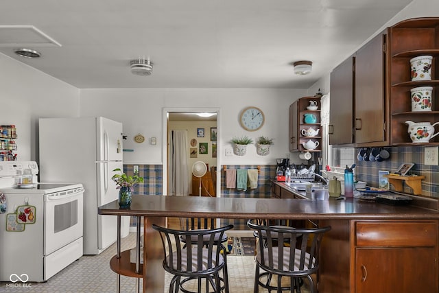 9030 E 700 S, Elizabethtown, IN 47232 - kitchen featuring white appliances, open shelves, dark countertops, light flooring, and a breakfast bar