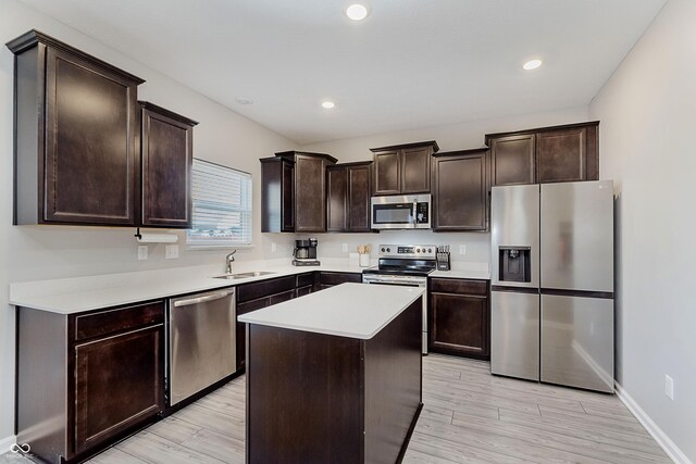 5809 Terracotta Trce, Mccordsville, IN 46055 - kitchen featuring appliances with stainless steel finishes, dark brown cabinetry, light wood-style floors, light countertops, and a center island