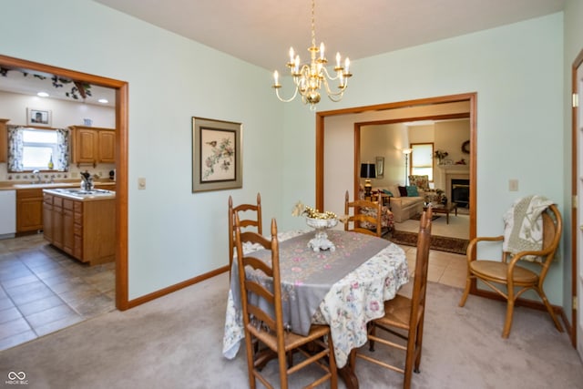 439 Alisa Ave, Seymour, IN 47274 - dining area featuring light colored carpet, a chandelier, a fireplace, and light tile patterned floors