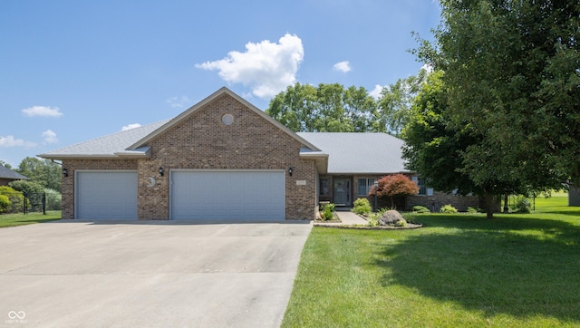 439 Alisa Ave, Seymour, IN 47274 - view of front of home featuring a garage, a front yard, driveway, and brick siding
