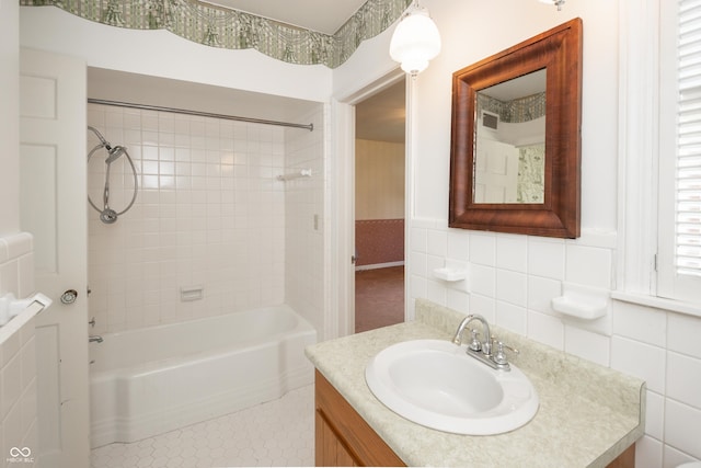 660 E Dr, Seymour, IN 47274 - bathroom with vanity, washtub / shower combination, tile walls, tile patterned floors, and a wainscoted wall