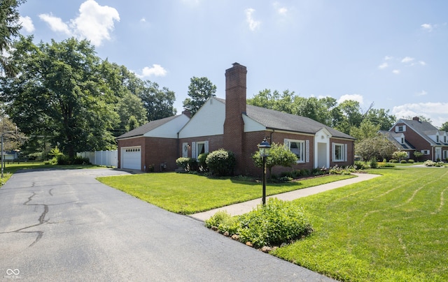 660 E Dr, Seymour, IN 47274 - view of front of property with a garage, a front lawn, brick siding, and a chimney