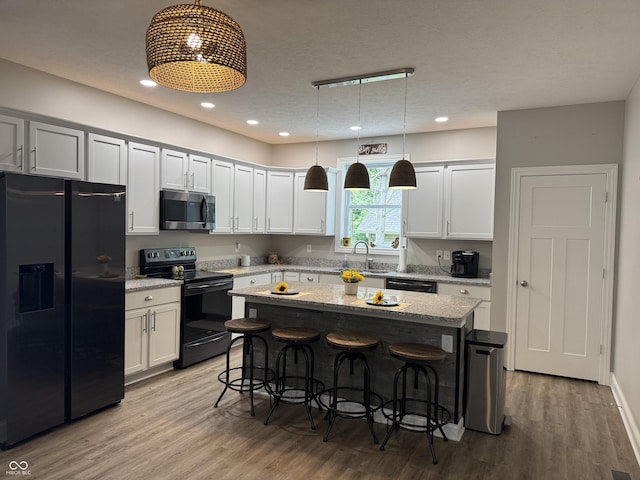 188 Gettysburg, Coatesville, IN 46121 - kitchen with refrigerator with ice dispenser, black / electric stove, stainless steel microwave, a kitchen breakfast bar, and dishwashing machine