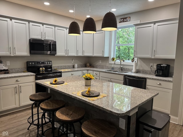 188 Gettysburg, Coatesville, IN 46121 - kitchen with stainless steel microwave, dishwasher, wood finished floors, a breakfast bar area, and a center island