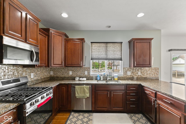 7350 Gold King Way, Indianapolis, IN 46259 - kitchen featuring stainless steel appliances, dark stone counters, tasteful backsplash, recessed lighting, and a peninsula
